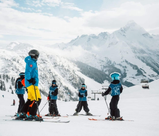 Ski lesson in Schools Go Skiing bibs with the instructor